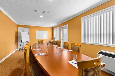 a conference room with a long wooden table and chairs at Coast Fraser Inn in Williams Lake