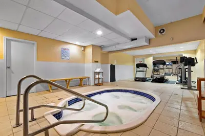 a hot tub in a fitness room with a gym at Coast Fraser Inn in Williams Lake