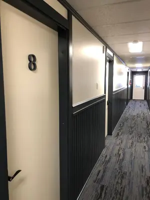 a corridor of an office with a door with a number on it at Dawson Lodge in Dawson City
