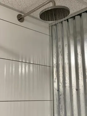 a shower with a shower curtain in a bathroom at Dawson Lodge in Dawson City