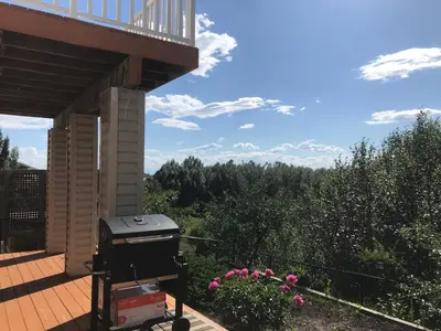 a barbecue grill on a deck with a balcony at 民宿Ann's House in Calgary in Calgary