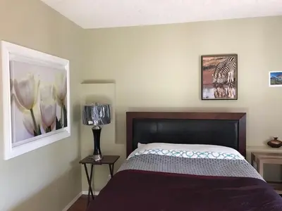 a bedroom with a bed and a picture on the wall at 民宿Ann's House in Calgary in Calgary