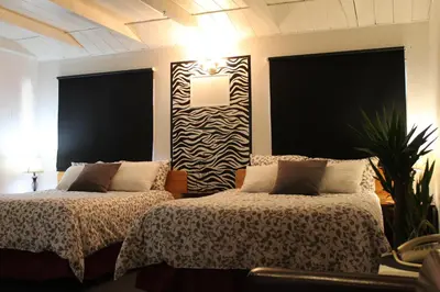 two beds in a room with black and white at Sage Hills Motel in Cache Creek