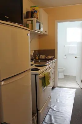 a kitchen with a white stove and a refrigerator at Sage Hills Motel in Cache Creek