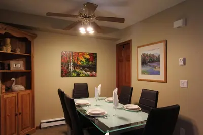 a dining room with a table with chairs and a ceiling fan at Lagoons Condos by Whistler Retreats in Whistler