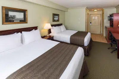 a hotel room with two beds and a television at Quality Inn & Suites in Whitecourt