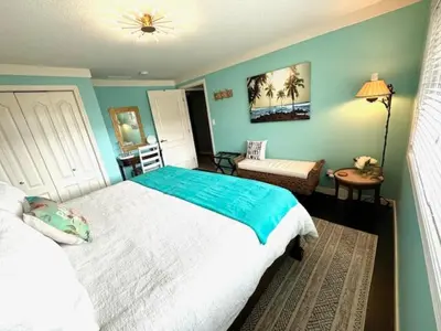 a bedroom with a bed and a table and a chair at The Blue House Bed and Breakfast in Lake Country