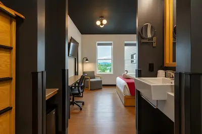 a hotel room with a sink and a bed at Raven Inn Whitehorse in Whitehorse