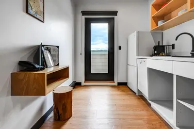 a kitchen with white counters and a door and a wooden floor at Raven Inn Whitehorse in Whitehorse