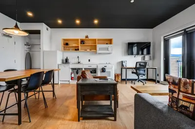 a living room with a table and a dining room at Raven Inn Whitehorse in Whitehorse