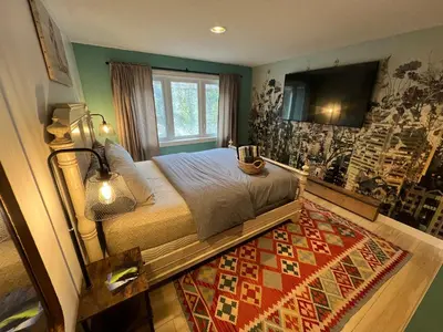 a bedroom with a bed with a television and a rug at \u597d\u4e18\u3002Hacho House in Yellowknife