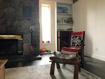 a living room with a chair and a stone fireplace at \u597d\u4e18\u3002Hacho House in Yellowknife