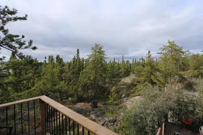 a wooden balcony with a view of a forest at \u597d\u4e18\u3002Hacho House in Yellowknife