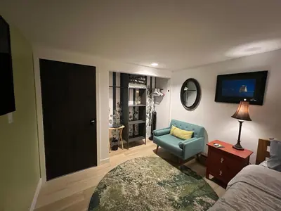 a bedroom with a bed and a chair and a tv at \u597d\u4e18\u3002Hacho House in Yellowknife