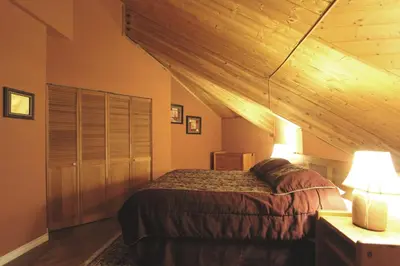 a bedroom with a bed and a wooden ceiling at Rainbow Suites by Whistler Retreats in Whistler