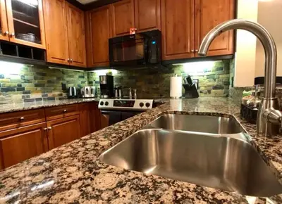 a kitchen with a stainless steel sink and wooden cabinets at Luxurious & Spacious Mountain Retreat in Canmore