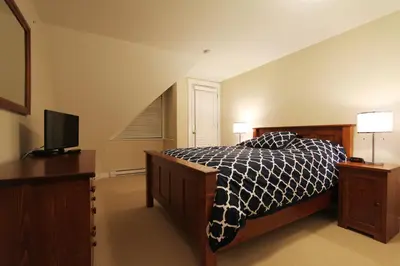 a bedroom with a bed and a tv in it at Villas Snowberry by Whistler Retreats in Whistler