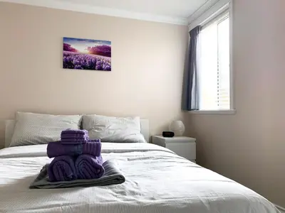 a bedroom with a bed with purple yarn on it at Perfect Location - Entire Suite Private Entrance with private bathroom & living room - 5 Mins Walk to Skytrain & Restaurant & Banks, 2 Stops To Metrotown, 5 Stops To Downtown in Vancouver