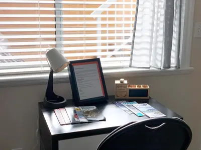 a desk with a lamp and a laptop on it at Perfect Location - Entire Suite Private Entrance with private bathroom & living room - 5 Mins Walk to Skytrain & Restaurant & Banks, 2 Stops To Metrotown, 5 Stops To Downtown in Vancouver