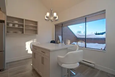 a kitchen with a table and chairs and a window at Whistler Blackcomb Vacation Rentals - Village North in Whistler