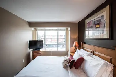 a bedroom with a bed and a window at Whistler Blackcomb Vacation Rentals - Village North in Whistler