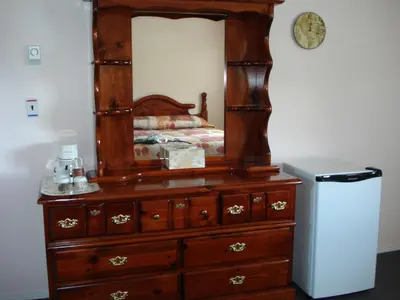 a dresser with a mirror on top of it at Mountain Springs Motel & RV Park in Barrière