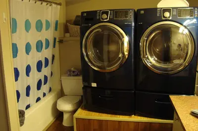 a washer and dryer in a bathroom with a toilet at YPC Fitness & Accomodations in Invermere