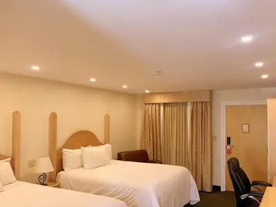 a hotel room with two beds and a chair at Park Place Lodge in Fernie
