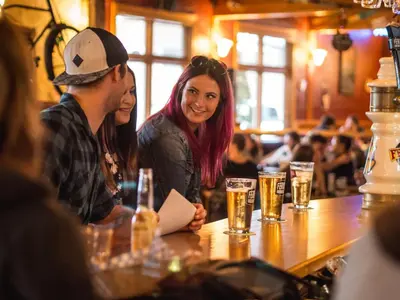 a group of people sitting at a table in a bar at Park Place Lodge in Fernie