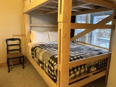 a bedroom with a bunk bed and a chair at Cornerstone Lodge by Park Vacation Management in Fernie