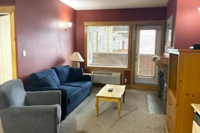 a living room with a blue couch and a table at Cornerstone Lodge by Park Vacation Management in Fernie
