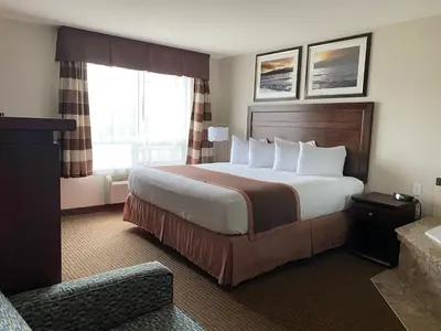 a hotel room with a large bed and a window at Ramada by Wyndham Creston in Creston