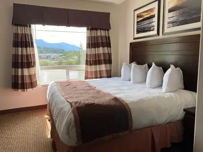 a hotel room with a bed with a large window at Ramada by Wyndham Creston in Creston