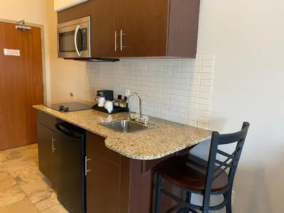 a kitchen with a sink and a counter with a chair at Ramada by Wyndham Creston in Creston