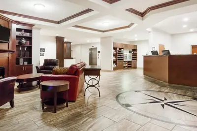 a lobby with a red couch and a table at Ramada by Wyndham Creston in Creston