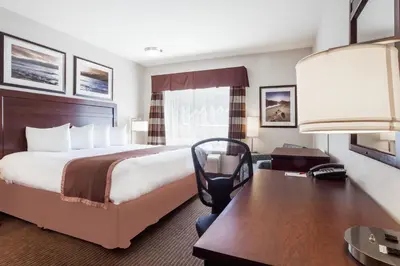 a hotel room with a bed and a desk at Ramada by Wyndham Creston in Creston