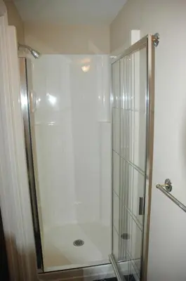 a shower with a glass door in a bathroom at Cambie Lodge in Vancouver