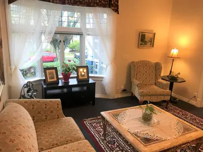 a living room with a couch and a table and a window at Cambie Lodge in Vancouver