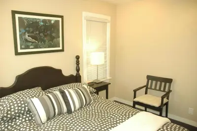 a bedroom with a bed and a chair and a window at Cambie Lodge in Vancouver