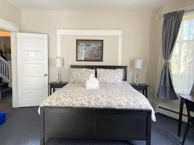 a bedroom with a bed with two tables and two lamps at Douglas Guest House in Vancouver