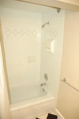 a white bathroom with a tub and a shower at Douglas Guest House in Vancouver