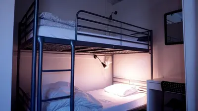 a room with two bunk beds and a television at HI Vancouver Jericho Beach - Hostel in Vancouver