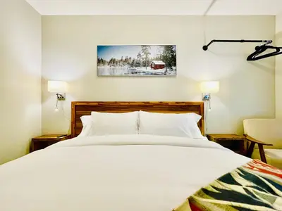 a bedroom with a large white bed and a chair at Joe's Contemporary 2 King Bedrooms Vacation Home in Canmore in Canmore