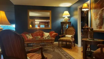 a living room with a couch and a mirror at Hidden Valley Bed and Breakfast in Whitehorse