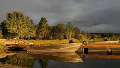 a boat is docked at a dock in the water at Barney’s Lakeside Resort in Puntzi Lake