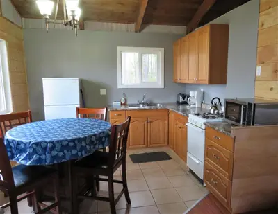 a kitchen with a table with a blue table cloth on it at Barney’s Lakeside Resort in Puntzi Lake