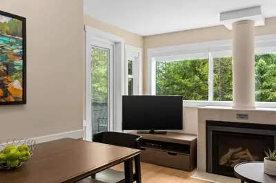 a living room with a fireplace and a television at Worldmark Whistler Sundance in Whistler