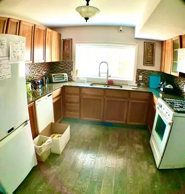 a kitchen with wooden cabinets and a sink and a refrigerator at Good location in Surrey