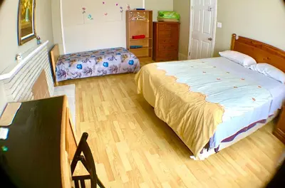 a bedroom with a large bed and a dresser at Good location in Surrey