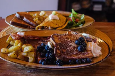 two plates of breakfast food with french toast and french beans at The Fraser River's Edge B&B Lodge in Chilliwack
